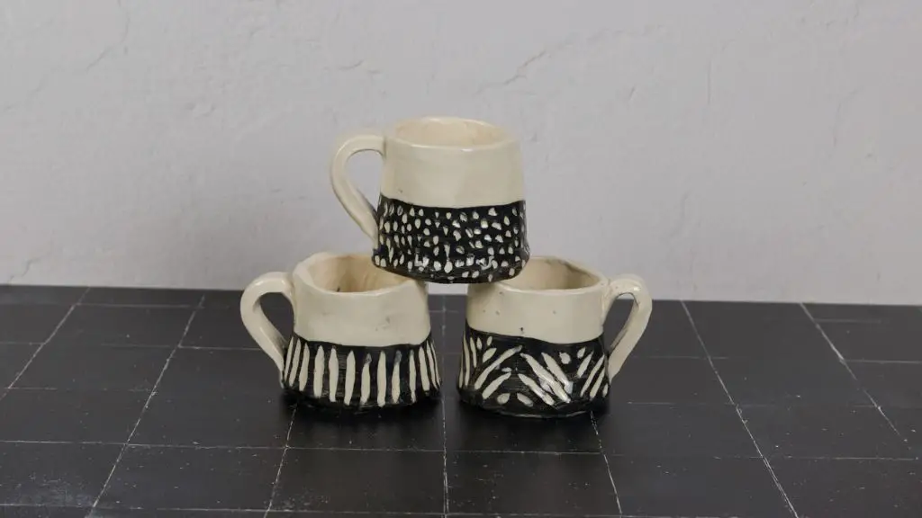 a ceramic mug with an underglaze design before glazing