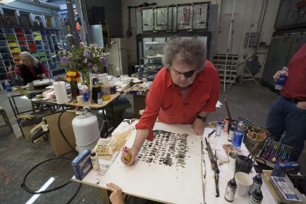 a ceramic technician repairs a broken piece of glass artwork in dale chihuly's studio.