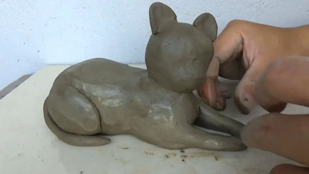 a child sculpting an animal out of clay
