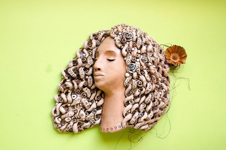 a clay plaque with sculpted circular coils creating a decorative wall hanging