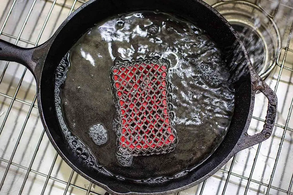 a durable silicone sponge cleaning a pan