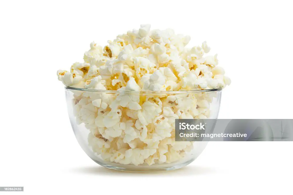 a large glass bowl filled with freshly popped popcorn