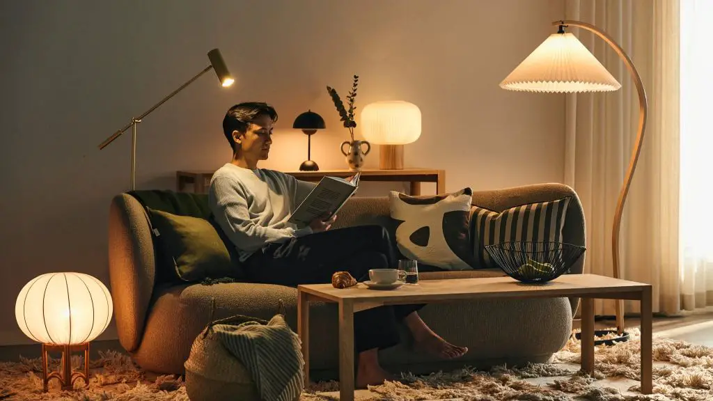 a linen lampshade emitting a soft, diffused glow over a chair in a living room