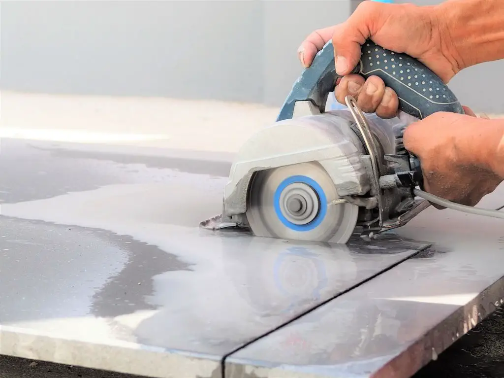 a man using a wet saw to cut tile