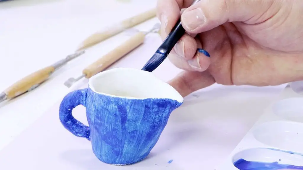 a person kneading and conditioning air dry clay before sculpting.