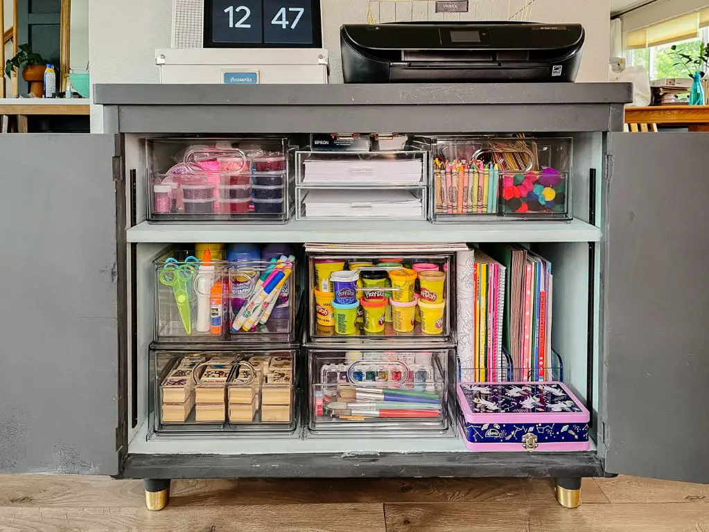 a picture of neatly organized art supplies on shelves and in bins to maximize vertical storage space in an art corner