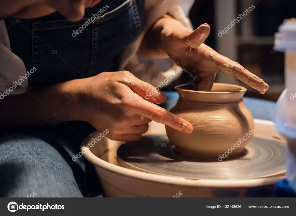 a potter sculpting a vase from clay on a pottery wheel