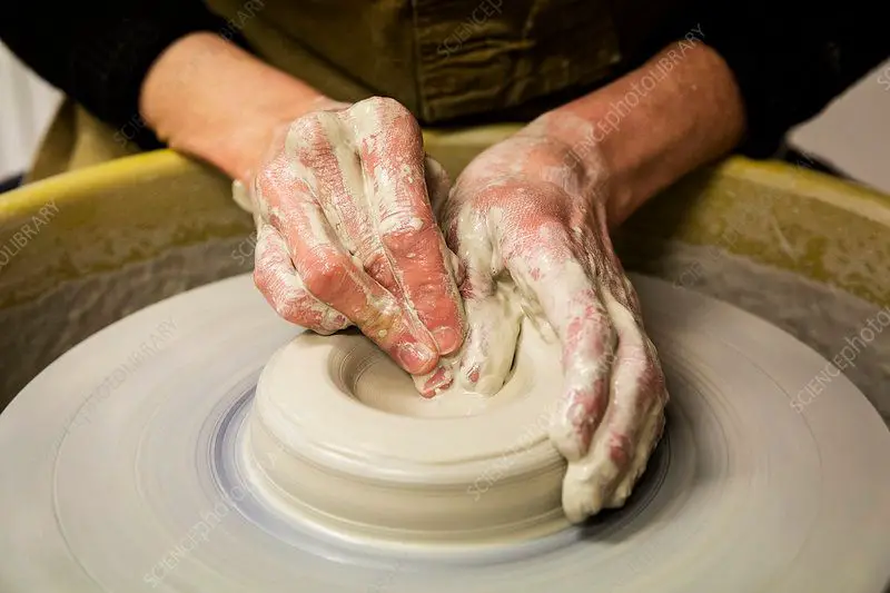 a potter shaping clay on a wheel