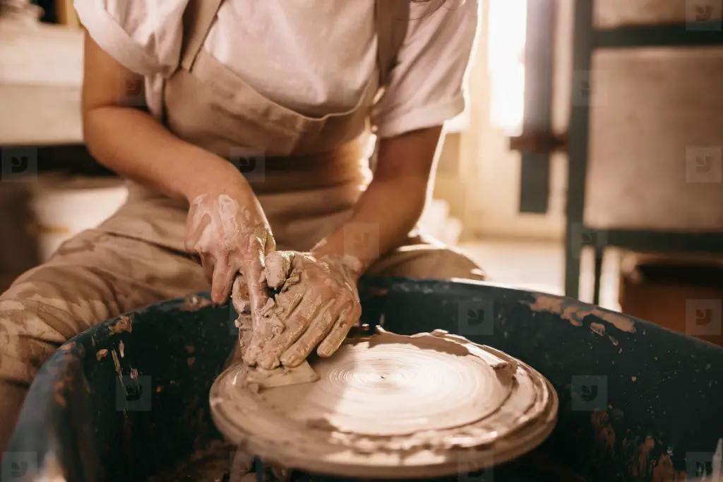 a potter shaping clay on a wheel