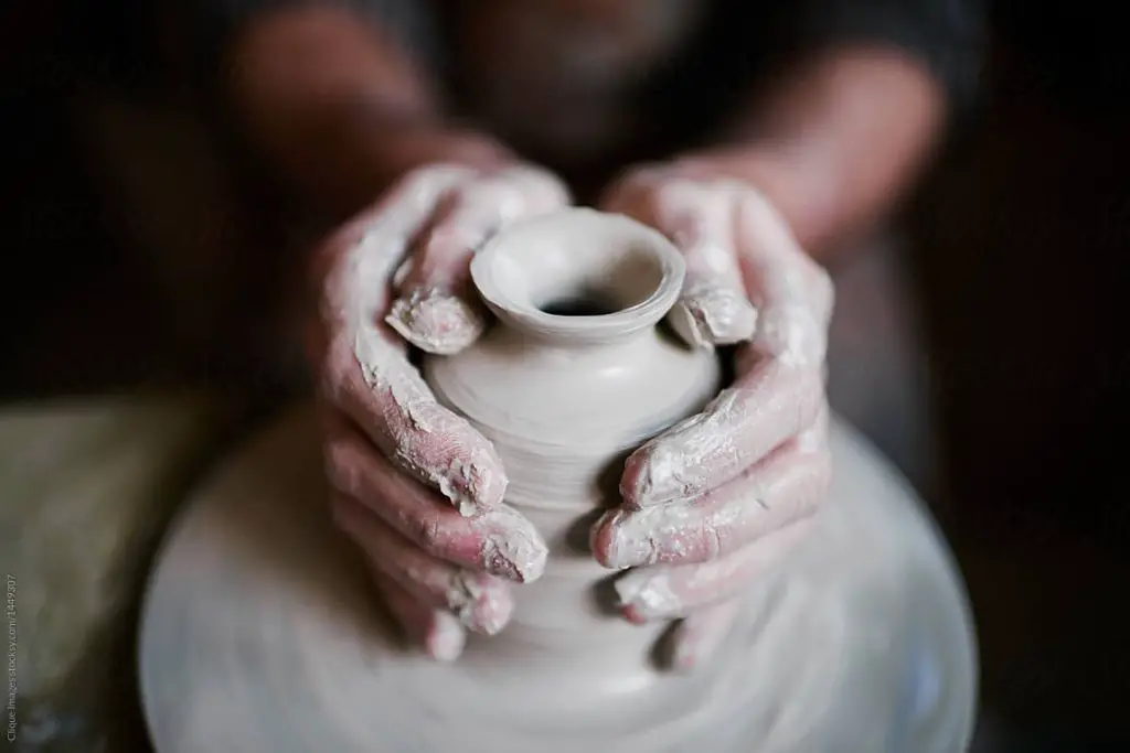 a potter shaping clay on a wheel