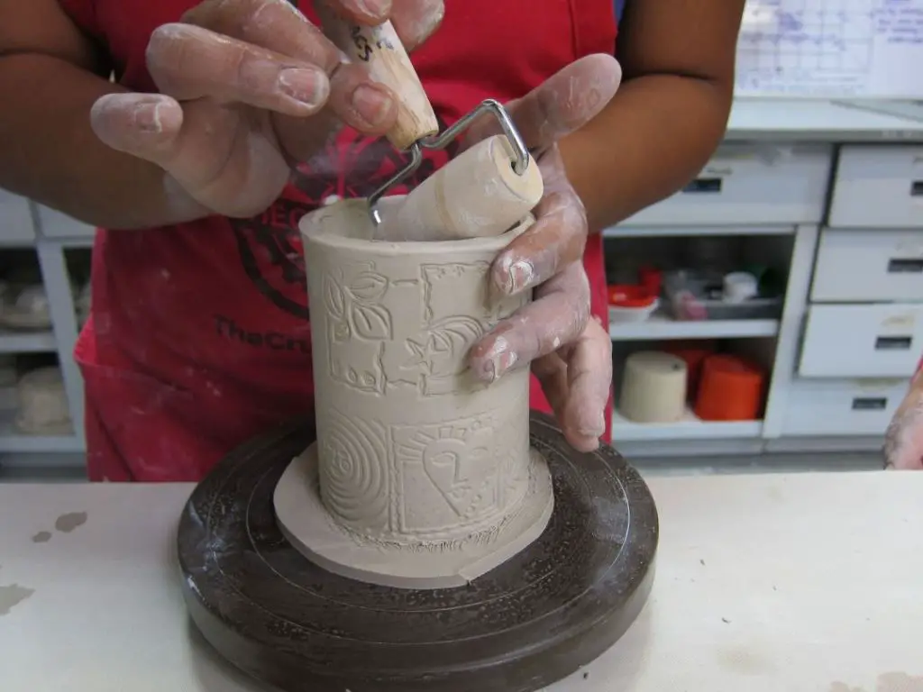 a potter working on a hand built ceramic vessel