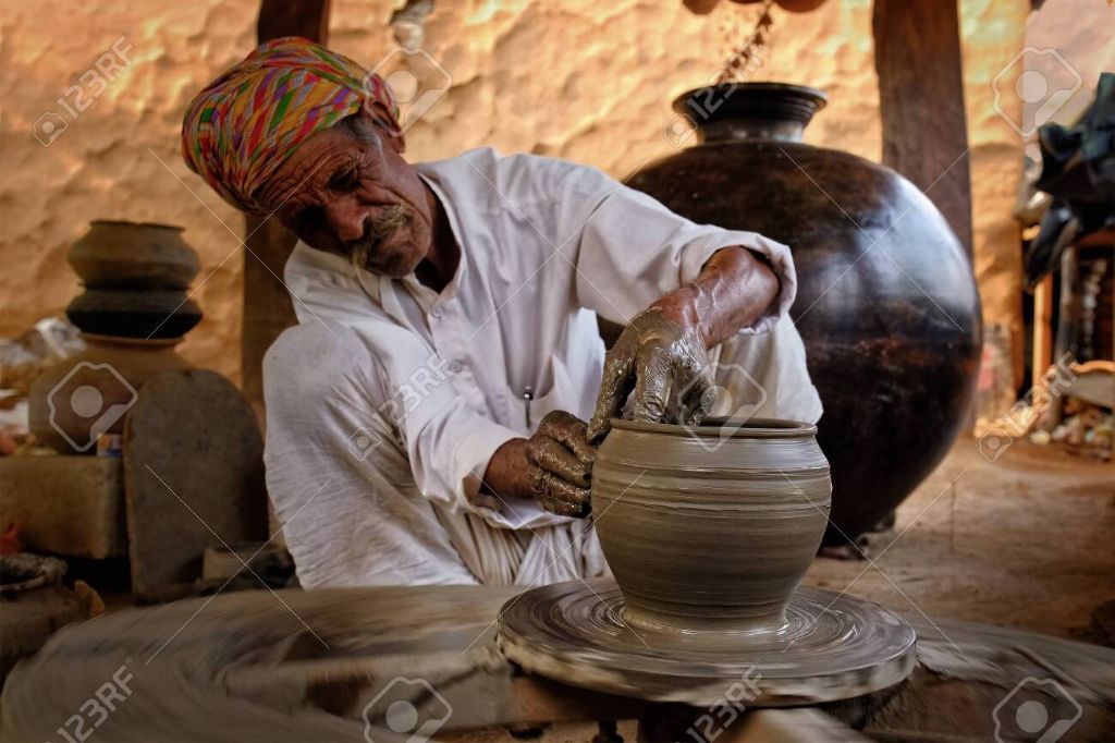 a potter working on a pottery wheel, shaping a clay vessel