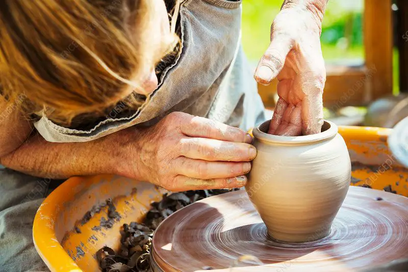 a potter working with clay on a wheel