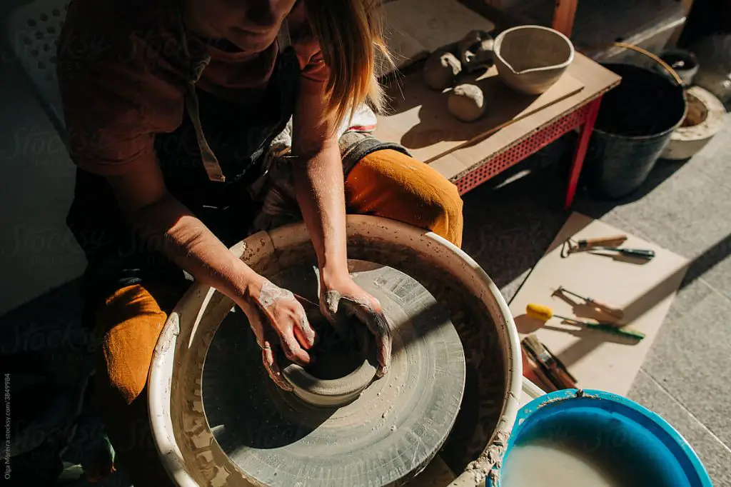 a pottery studio workspace with wheels, tools, and clay.