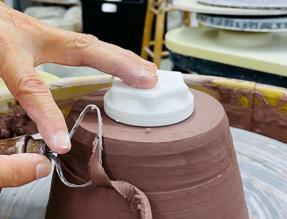 a pottery trimming spinner allows the precise shaping and refining of ceramic pieces after initial throwing on the wheel.