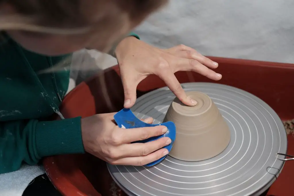 a pottery wheel allows shaping clay into symmetrical forms difficult to achieve by handbuilding.