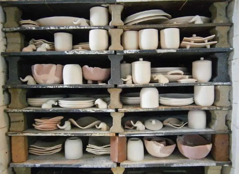 a row of clay plates on a kiln shelf ready to be fired to vitrify the clay and make them impervious to liquids.