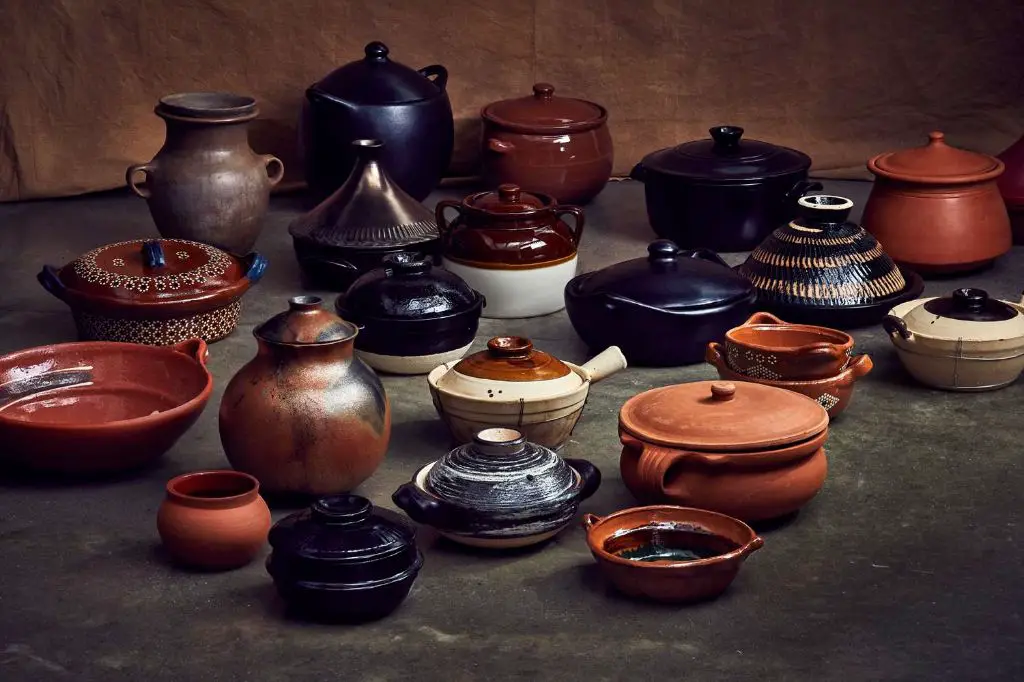 a variety of glazed and unglazed clay pots sitting on a table.