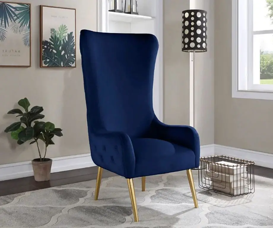 a wingback accent chair with navy blue velvet upholstery and wood legs.