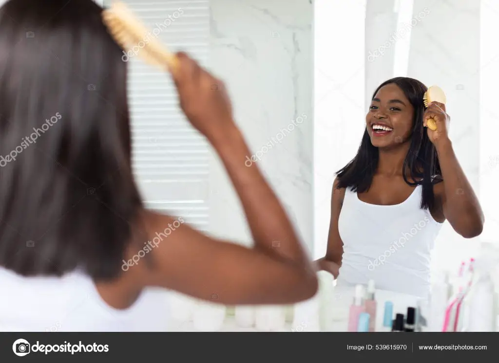 a woman brushing her hair with a bamboo brush