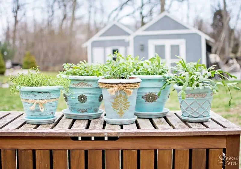 an antique clay flower pot next to a modern plastic flower pot