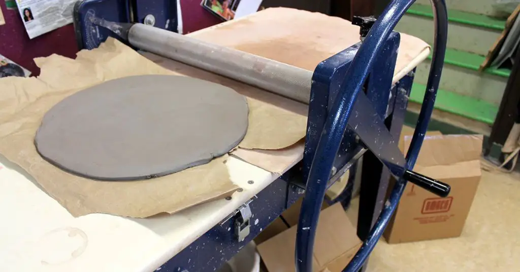 an electric slab roller being used to create a smooth clay slab