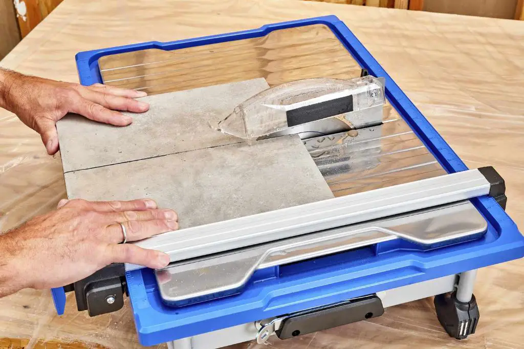 an electric tile cutter with a sliding table and overhead cutting arm to cut ceramic tiles