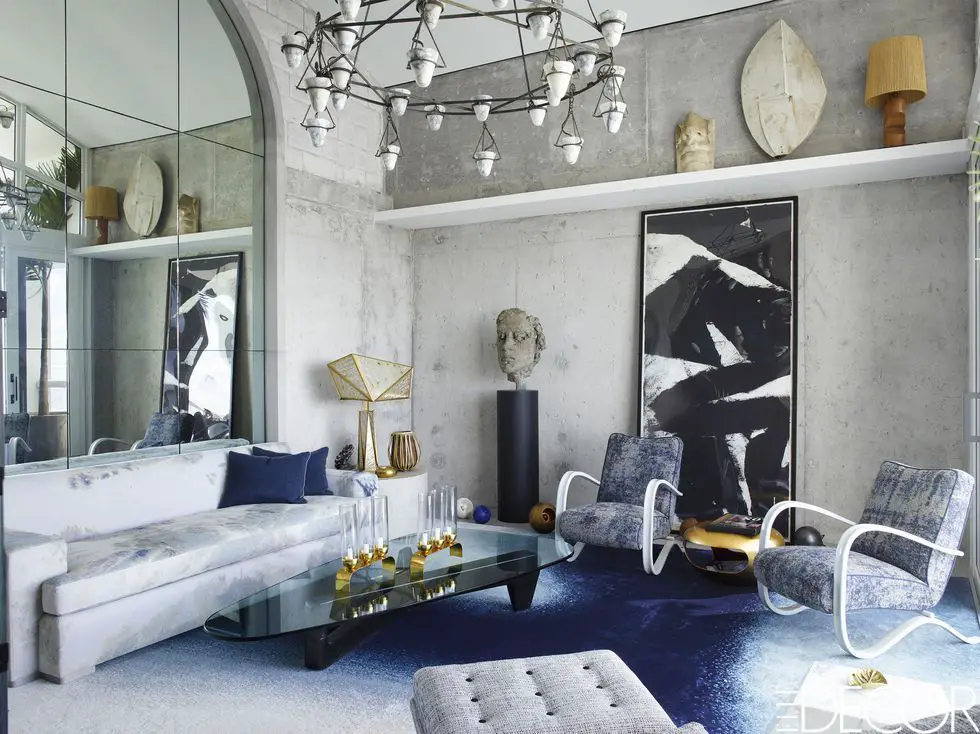 an elegantly styled glass top side table next to a modern gray sofa