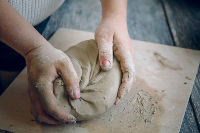 an example image showing the process of wedging and kneading a clay mixture.