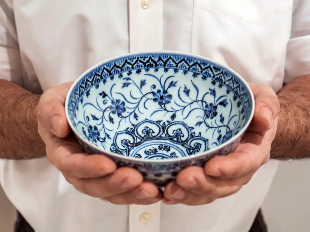 an image of a delicate porcelain bowl that has a chip on the rim, showing how porcelain can chip easily.