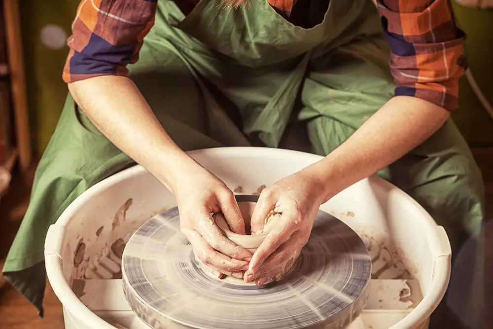 an image showing a roman potter shaping a vessel on a potter's wheel