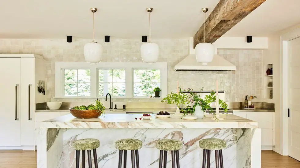 an island pendant light hanging over a kitchen island