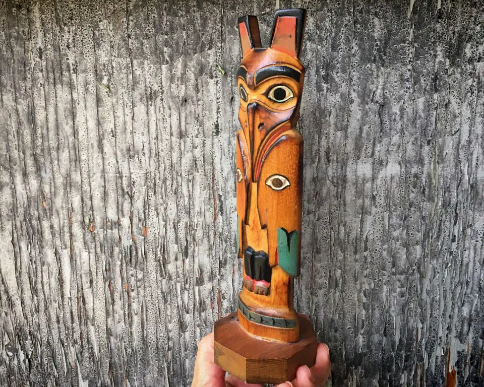 an owl totem pole being carved by a native american artist