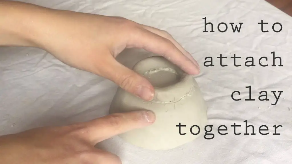 applying clay slip to join two pieces of pottery