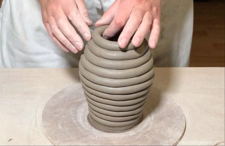 attaching the first coil to the base of a clay pot