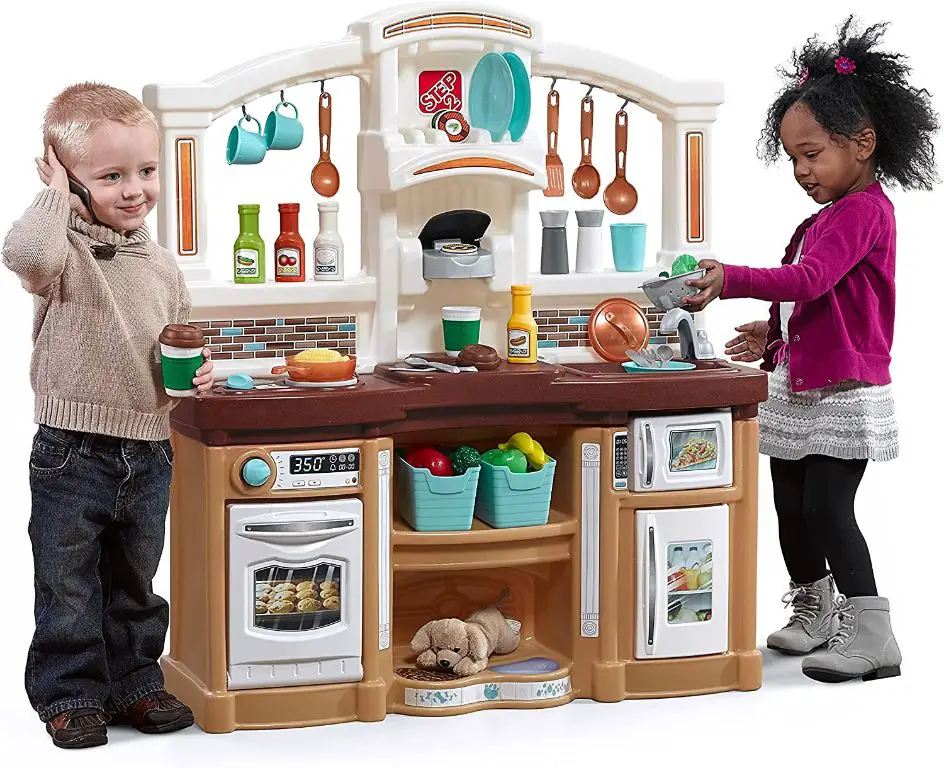 child playing pretend with toy kitchen set