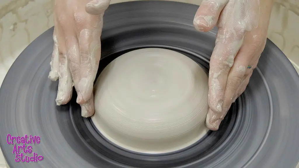 clay being centered on a pottery wheel