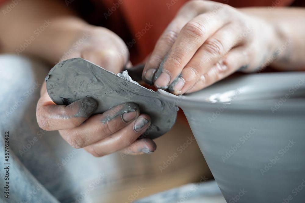 close up of trimming tools scraping clay on a pottery wheel