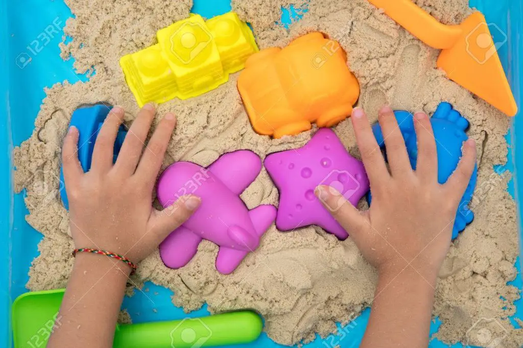 close up photo showing kinetic sand molding easily in a person's hands