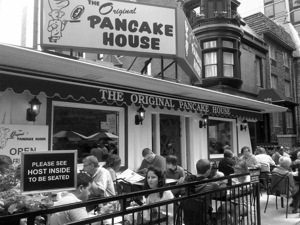 customers standing in a long line outside the original pancake house restaurant in 1953 portland, oregon.