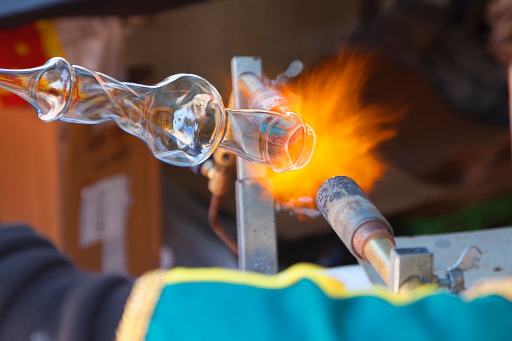 glassblower working with molten glass heated to a malleable state