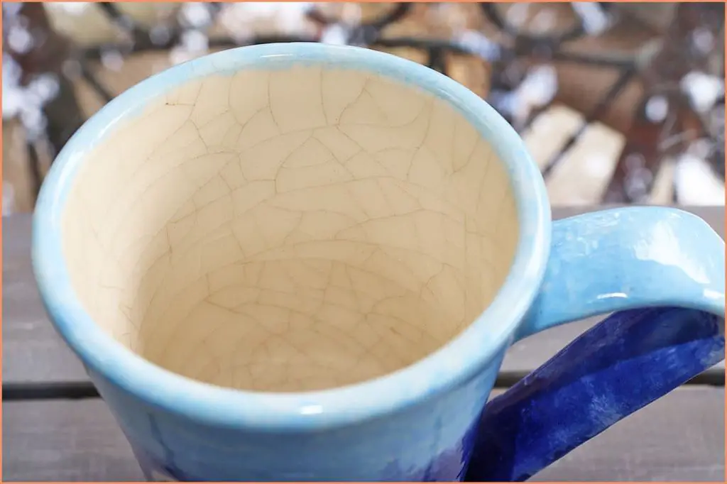 inspecting a ceramic mug for any cracks before placing in the dishwasher.