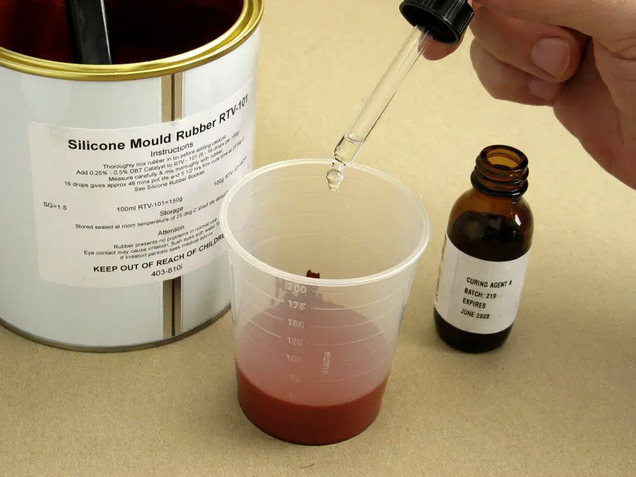 measuring out liquid silicone rubber on a scale before mixing it with a catalyst