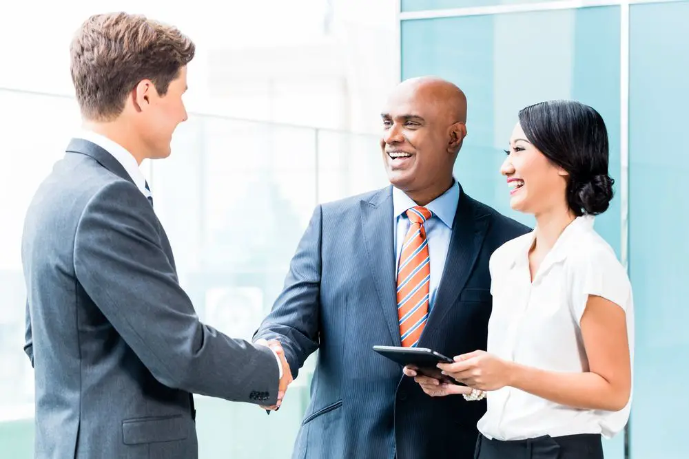 people in business attire shaking hands, networking and making connections to find job opportunities in new york city's competitive market.