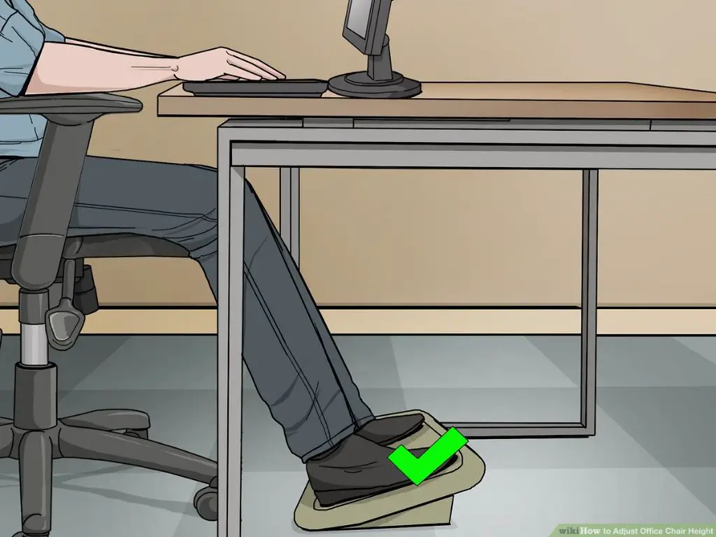 person adjusting the height of an office chair to align properly with the desk.