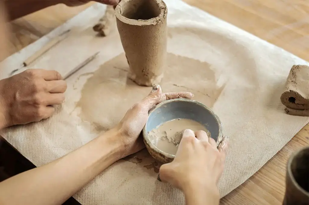 person constructing pottery slab piece