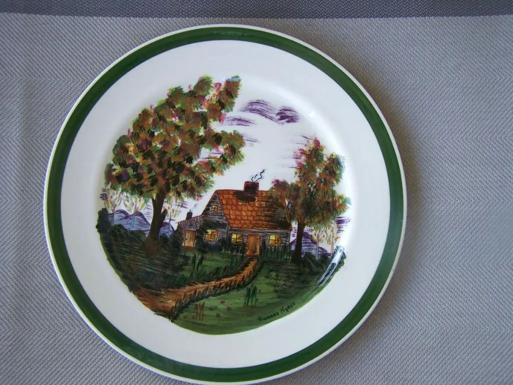 person gently handwashing a blue ridge pottery plate