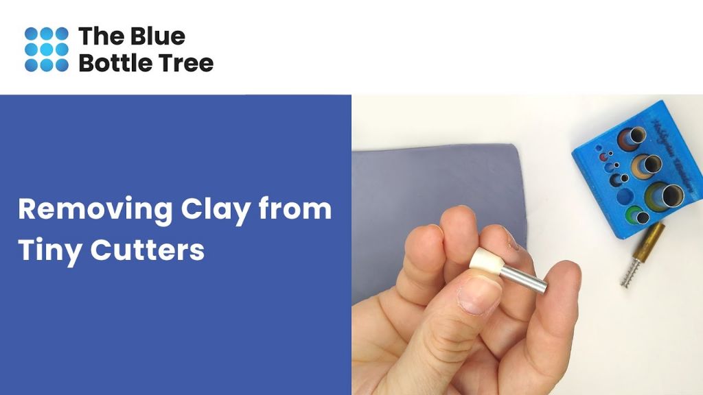 person gently tapping a polymer clay cutter against a table to remove a stuck clay shape