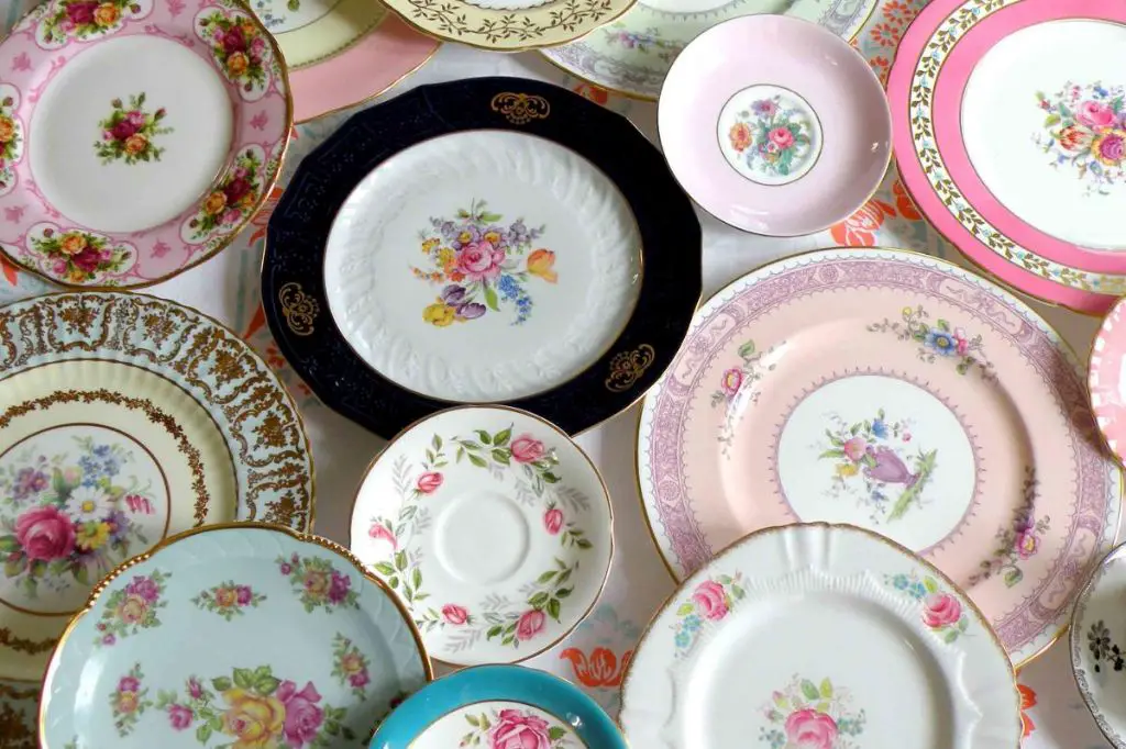 person handwashing a china plate to preserve the decorative pattern