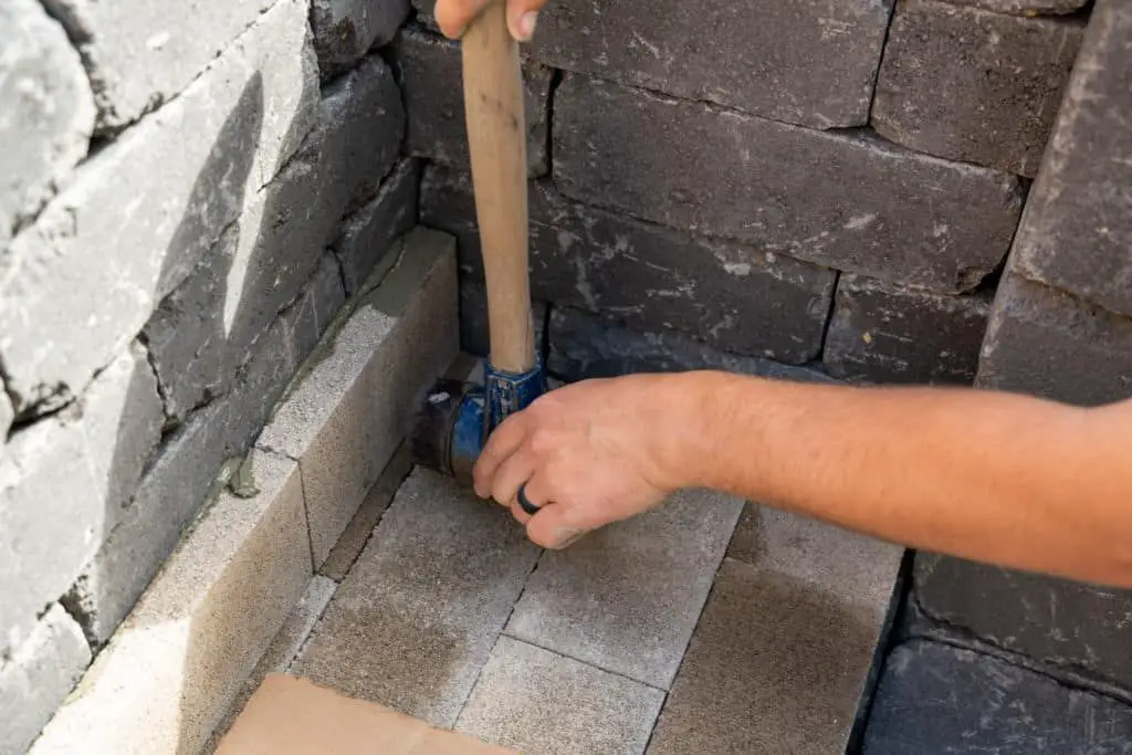 person placing firebricks to build a fireplace